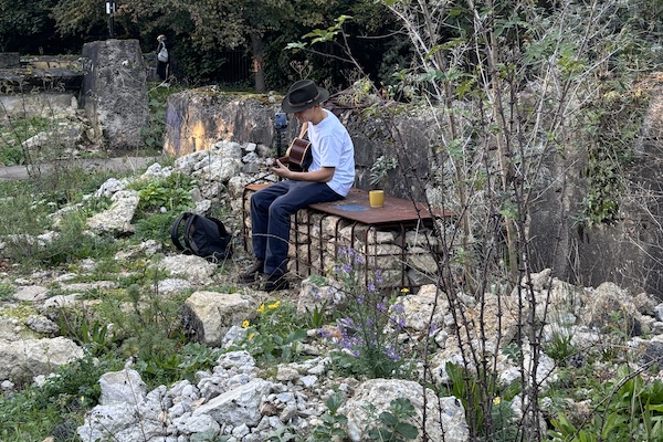 Person playing guitar in a Markfield Park wildlife garden